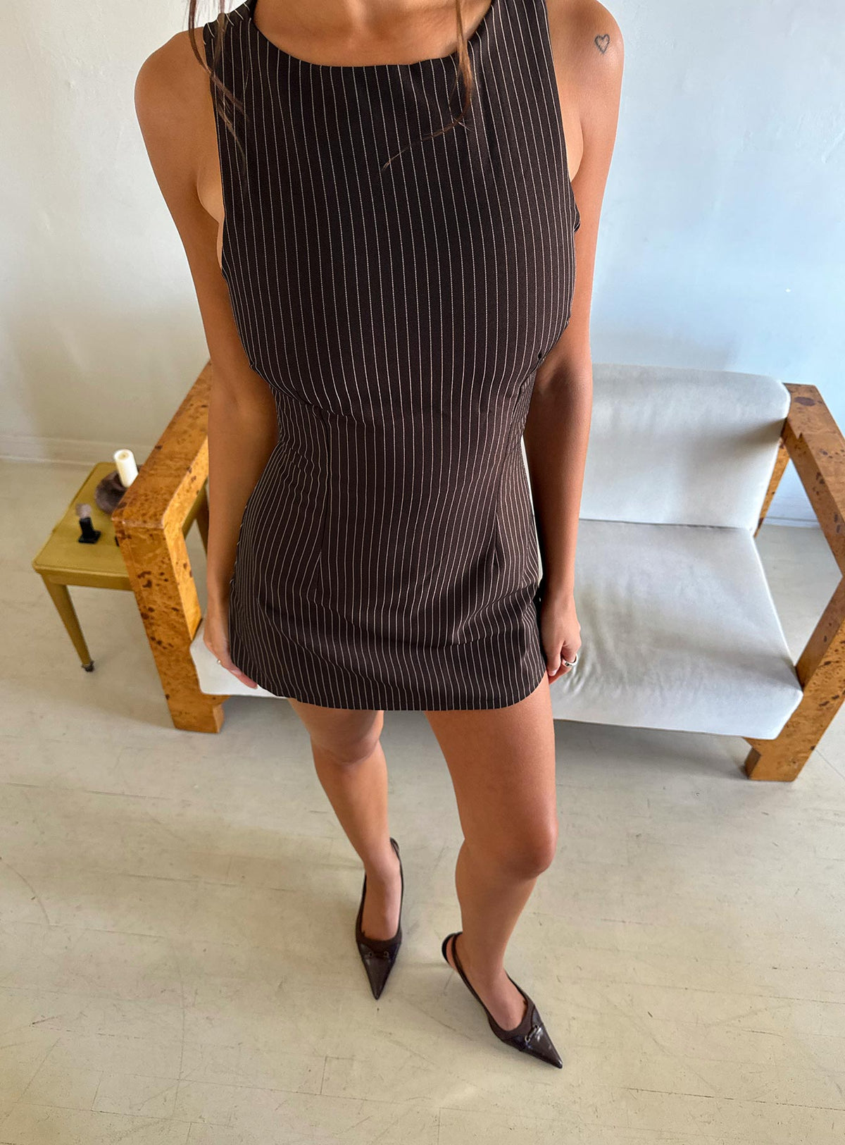 Full length view of a model wearing the brown pinstripe sleeveless playsuit