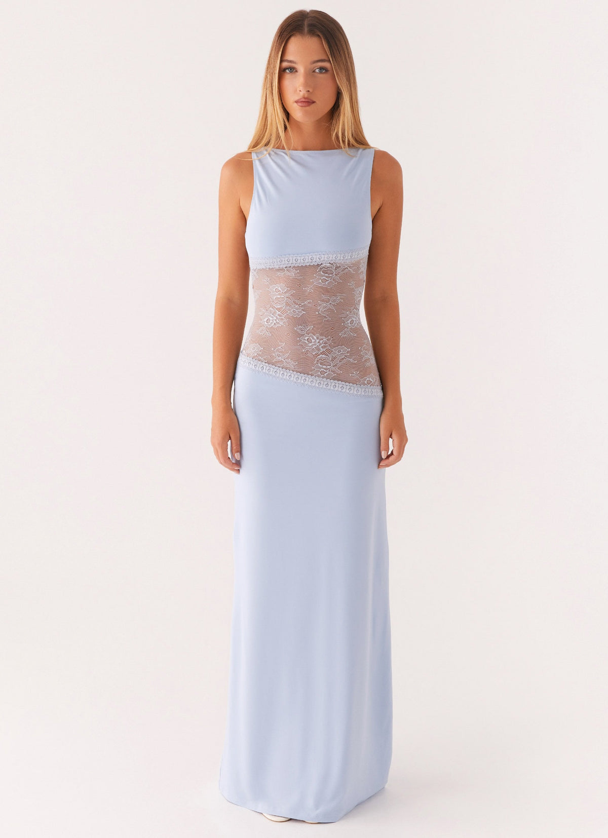 Model wearing a light blue jersey maxi dress with a high round neck and a diagonal sheer lace waist panel