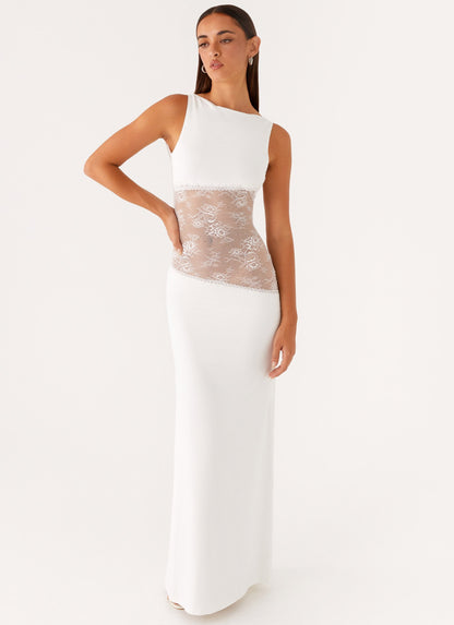 Model wearing a white jersey maxi dress with a high round neck and a diagonal sheer lace waist panel