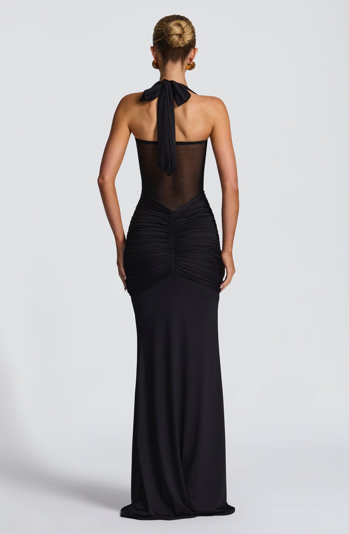 Back view of the black maxi dress showing the open mesh back and halter neck tie