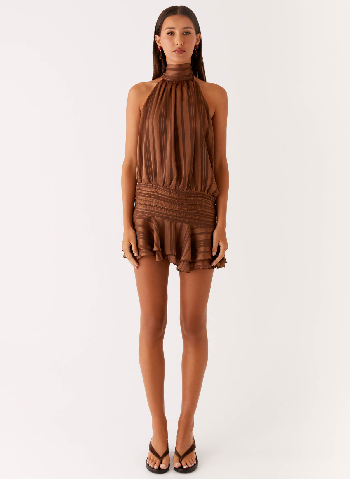 Full length view of a model wearing the chocolate chiffon halter neck mini dress