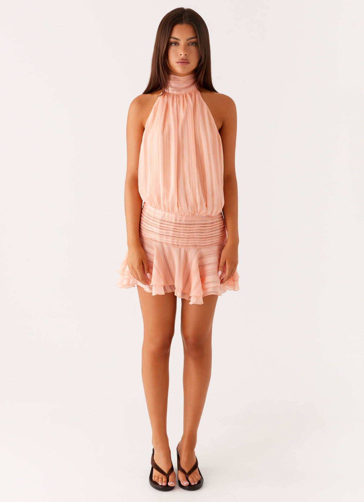 Full length view of a model wearing the orange chiffon halter neck mini dress