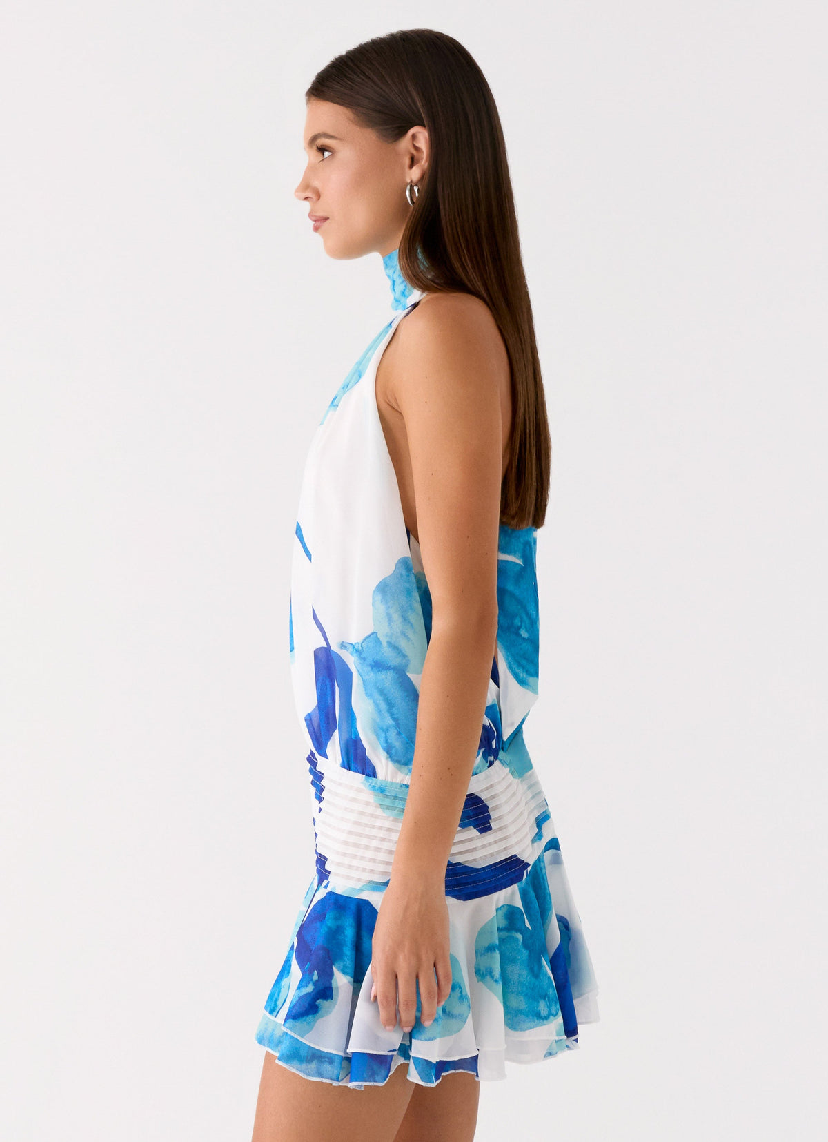Side view of the cerulean bloom chiffon halter neck mini dress showing the drop waist and flared hem